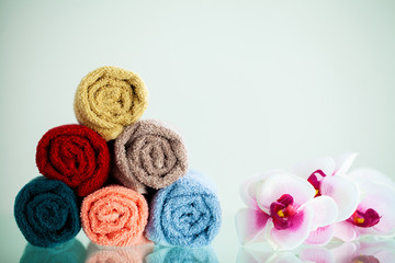 Colored towels and orchid on white table with copy space on bath room background