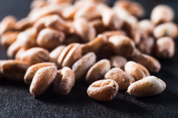 Bulk wholegrain wheat in grains close-up on a dark background. Macro shooting.