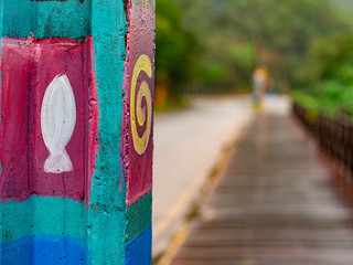 Painted lightpole with colorful graphisms with road extending into the background