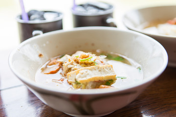 Tom yum pork noodles, close-up, blurred background 
