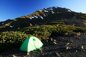 南アルプス　白峰三山テント縦走　朝陽に映える濃鳥小屋テント場の風景　間ノ岳を仰ぎ見る