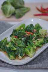 Stir-fried Brussels sprout with sun-dried crispy fish on the plate.