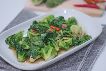 Stir-fried Brussels sprout with sun-dried crispy fish on the plate.