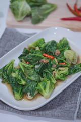 Stir-fried Brussels sprout with sun-dried crispy fish on the plate.
