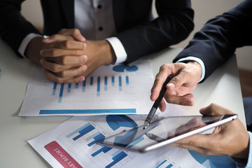 Business people use the tablet to learn and find information for work. View online information