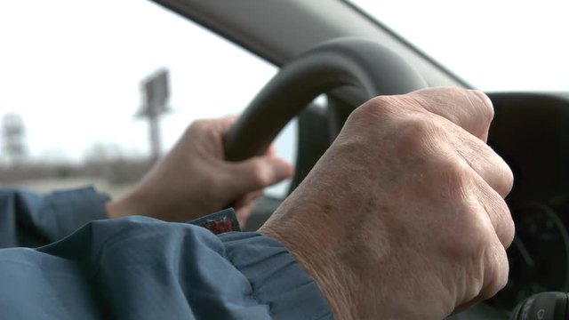 Elderly man gripping steering wheel slow motion