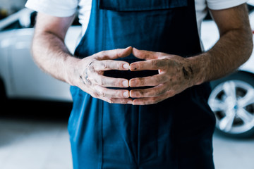 Cropped view of car mechanic standing with clenched hands