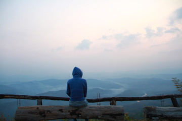 Lonely girl sit and look at the horizon of sky and the natural mountain. Miss lover on valentine's day