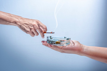 Man hand give a transparent ashtray to smoker