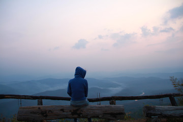 Lonely girl sit and look at the horizon of sky and the natural mountain. Miss lover on valentine's day