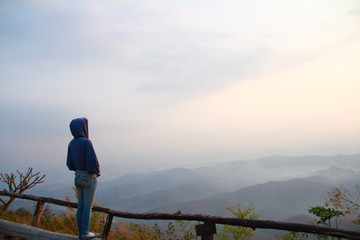 Lonely girl stand and look at the new day light of sky and the natural mountain. Miss lover on valentine's day