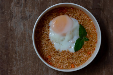 Spicy boiled instant noodles with soft-boiled egg on top. The precooked and dried noodle ready and easy to eat.