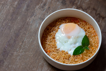 Spicy boiled instant noodles with soft-boiled egg on top. The precooked and dried noodle ready and easy to eat.