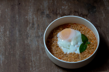 Spicy boiled instant noodles with soft-boiled egg on top. The precooked and dried noodle ready and easy to eat.