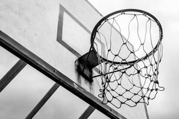 Black and white of Old basketball hoop on sky background and clouds