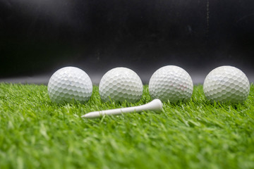Four golf balls are on green grass