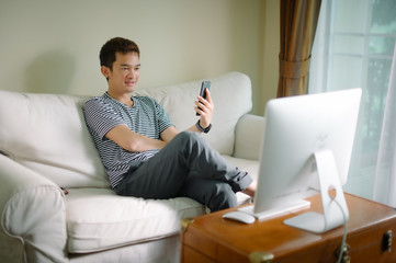 Young man sitting comfortably with laptop searching hotel accommodations online  trying to save on hotel stays  booking a room  checking out a selection of resorts