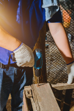 construction man workers in blue shirt with Protective gloves and working with power drill