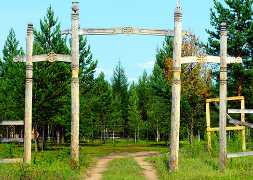Yakut entrance to the Park in the wild far North with religious symbols of the local faith, pillars and tree of life.