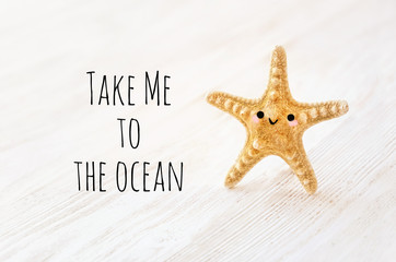 Fototapeta na wymiar Take Me to the ocean - inspiration quote of sea. cute kawaii starfish on abstract wooden white background. concept of relaxation, recreation, travel. soft selective focus