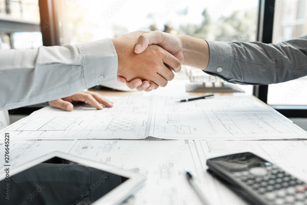 Poster architect and engineer construction workers shaking hands while working for teamwork and cooperation