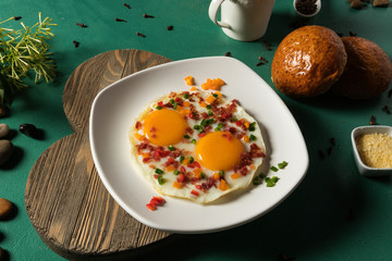 Huevos fritos con tocinera pepino rojo y verde pan y chocolate en fondo verde