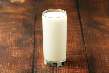 A glass with milk on a wooden rustic table
