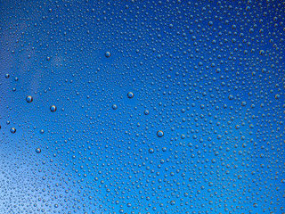 Water droplets on the glass with a colored background. Drops of water.