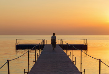 girl on pontoon pier at sunset