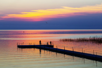 Naklejka na ściany i meble family on pontoon pier at sunset