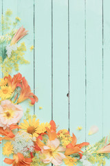 yellow and orange flowers on green wooden background