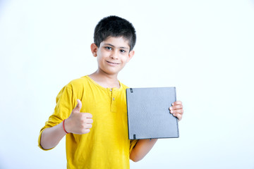 young indian boy showing notebook 