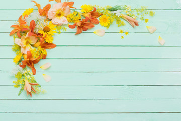 yellow and orange flowers on green wooden background