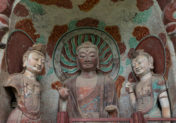 Sculpture of Maitreya Buddha and two attendant Bodhisattvas with colorful fresco in left niche at venrandah of Grotto 5 at Mount Maiji or Maijishan Grottoes, Tianshui, Gansu, China.
