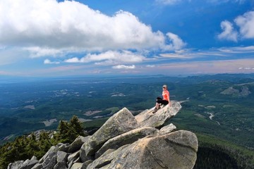 Woman hiker on rock above valley. Mount Pilchuck State Park near Seattle. Washington. United States...