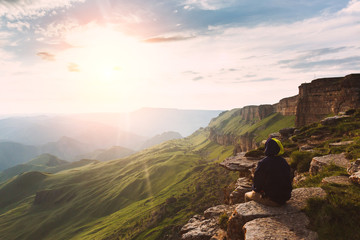 Travel man tourist alone on the edge caucasus rock mountains adventure lifestyle extreme vacations...