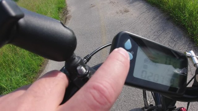 Cyclist turning on the ebike or electric bicycle and pushing button on the e bike controller. Onboard action camera focus on the road. View from first person perspective POV. 4k.