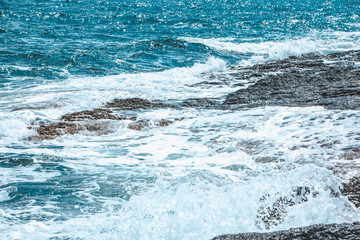 view of rocky seaside waves with white foam