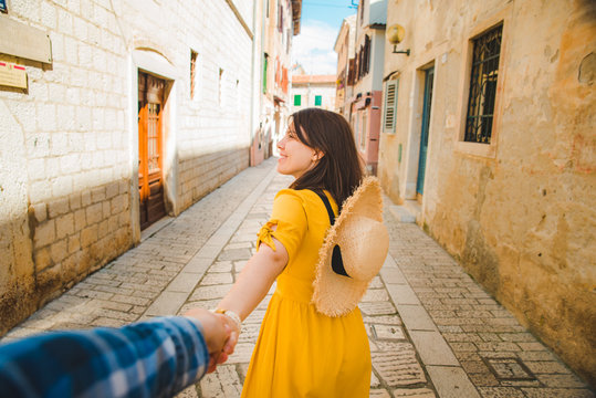 tourist woman in yellow sundress walking by small croatian city street