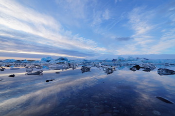 Fototapeta premium Reflections in Iceland's beautiful Jökulsárlón glacier lagoon at sunrise during winter