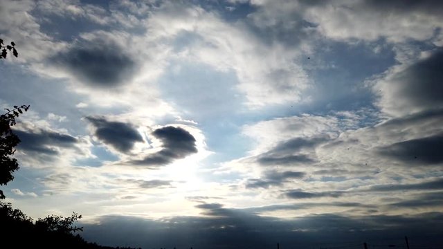 Evening sky with fast moving clouds. Sund behind the clouds, Motiontimelapse at the countryside in Germany.