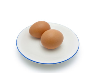 Whole eggs on the round plate isolated on white background