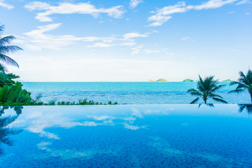 Fototapeta premium Umbrella and chair around beautiful luxury outdoor swimming pool with sea ocean view in hotel resort for holiday vacation travel