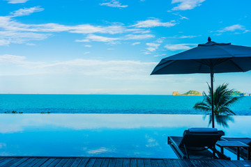 Umbrella and chair around beautiful luxury outdoor swimming pool with sea ocean view in hotel resort for holiday vacation travel