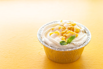 Summer fruit dessert is Mango cheesecake on yellow table background