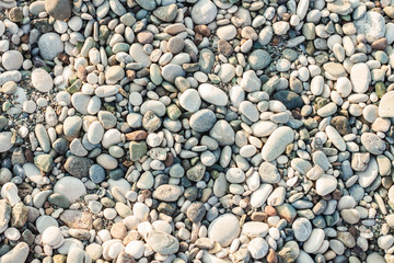 Beach stone pebbles. The texture of small stones and sand. Can be used as a texture, background or wallpaper
