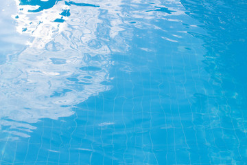 Water vibrations in the swimming pool with sun reflection. blue swimming pool surface, water background in swimming pool. Flat lay, top view