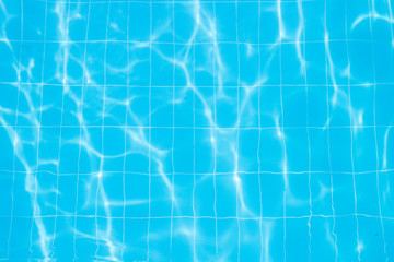 Water vibrations in the swimming pool with sun reflection. blue swimming pool surface, water background in swimming pool. Flat lay, top view