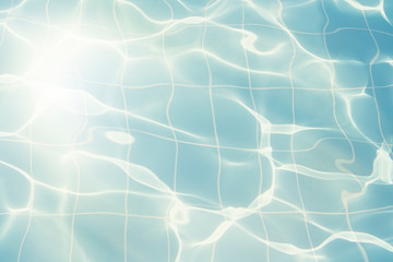 Water vibrations in the swimming pool with sun reflection. blue swimming pool surface, water background in swimming pool. Flat lay, top view