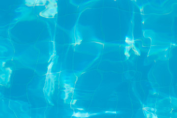 Water vibrations in the swimming pool with sun reflection. blue swimming pool surface, water background in swimming pool. Flat lay, top view